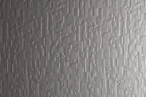 A close up of a grey wall with a pattern of squares.
