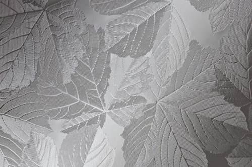 A white and silver leaf pattern on a wall.